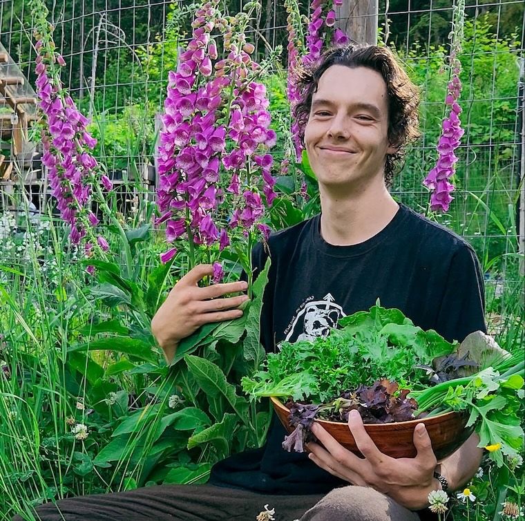 Seb Jagoe standing in a garden of foxgloves at Solarity Acres